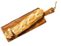 Nygräddad, delvis skivad baguette på en skärbräda i trä.