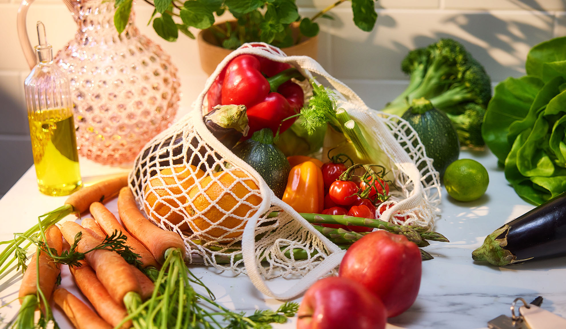 Färska grönsaker och frukter, som paprika, apelsiner och morötter, i en shoppingkasse.