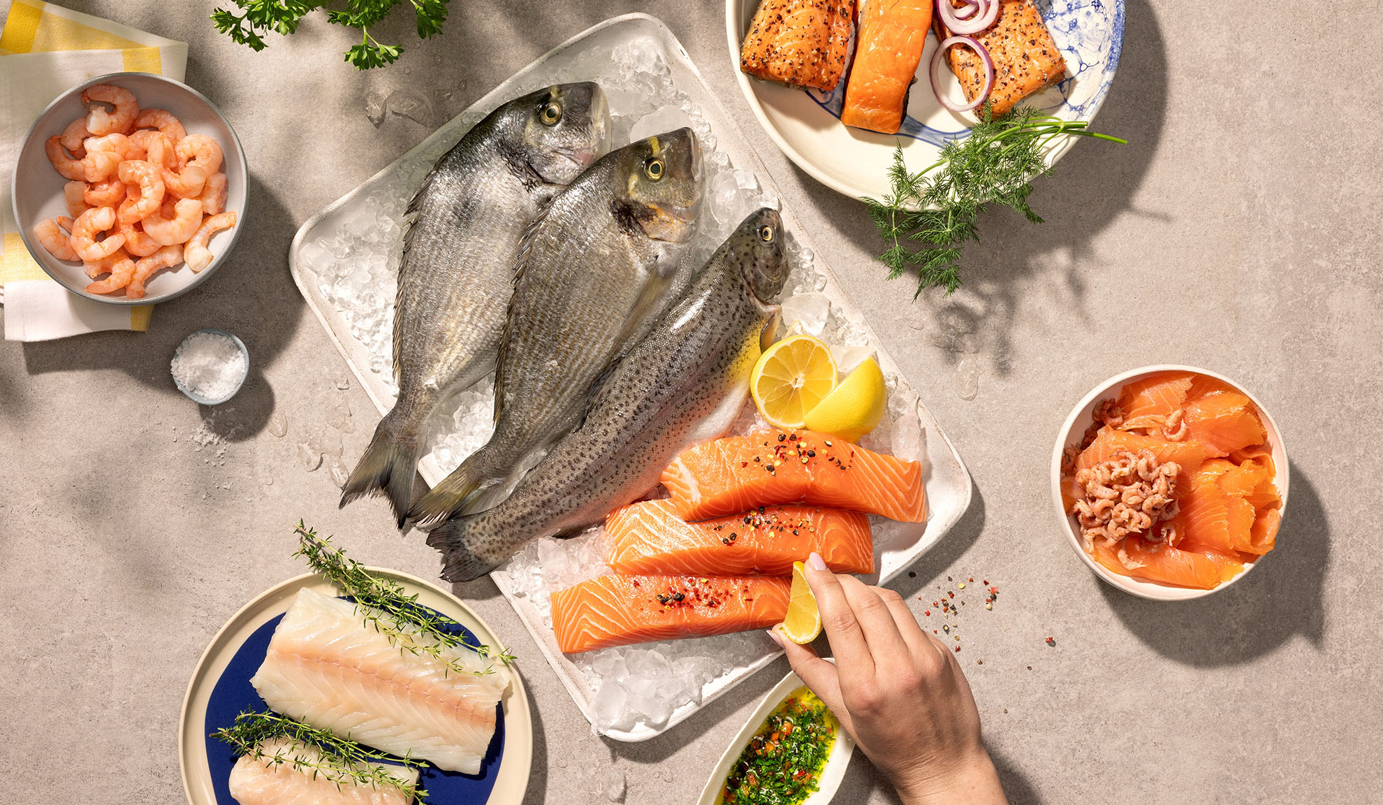 Assorterade färska skaldjur, inklusive fisk, lax och räkor, redo för matlagning.