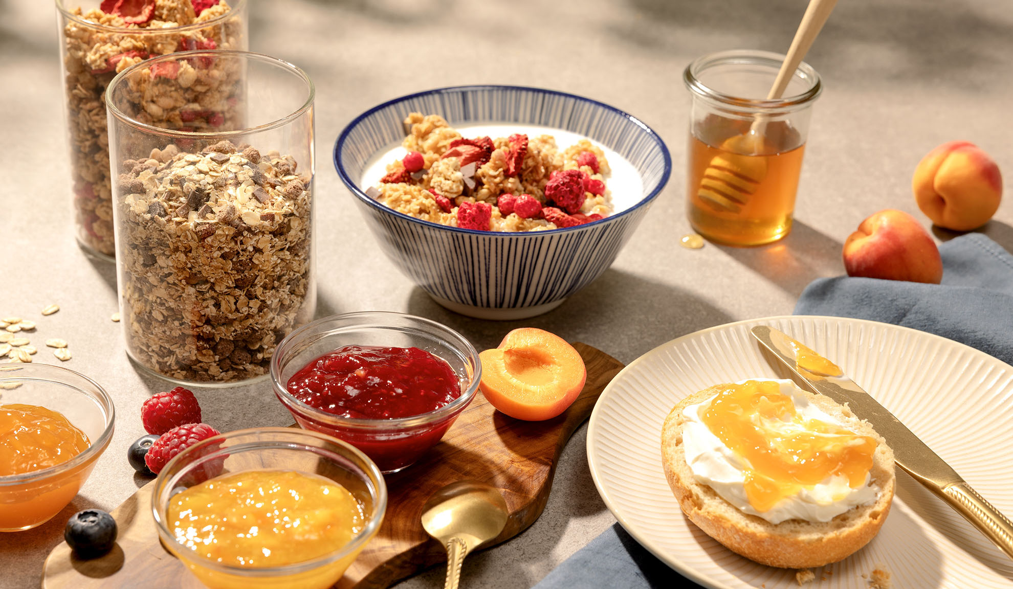 Frukost med granola, honung, sylt och färsk frukt.