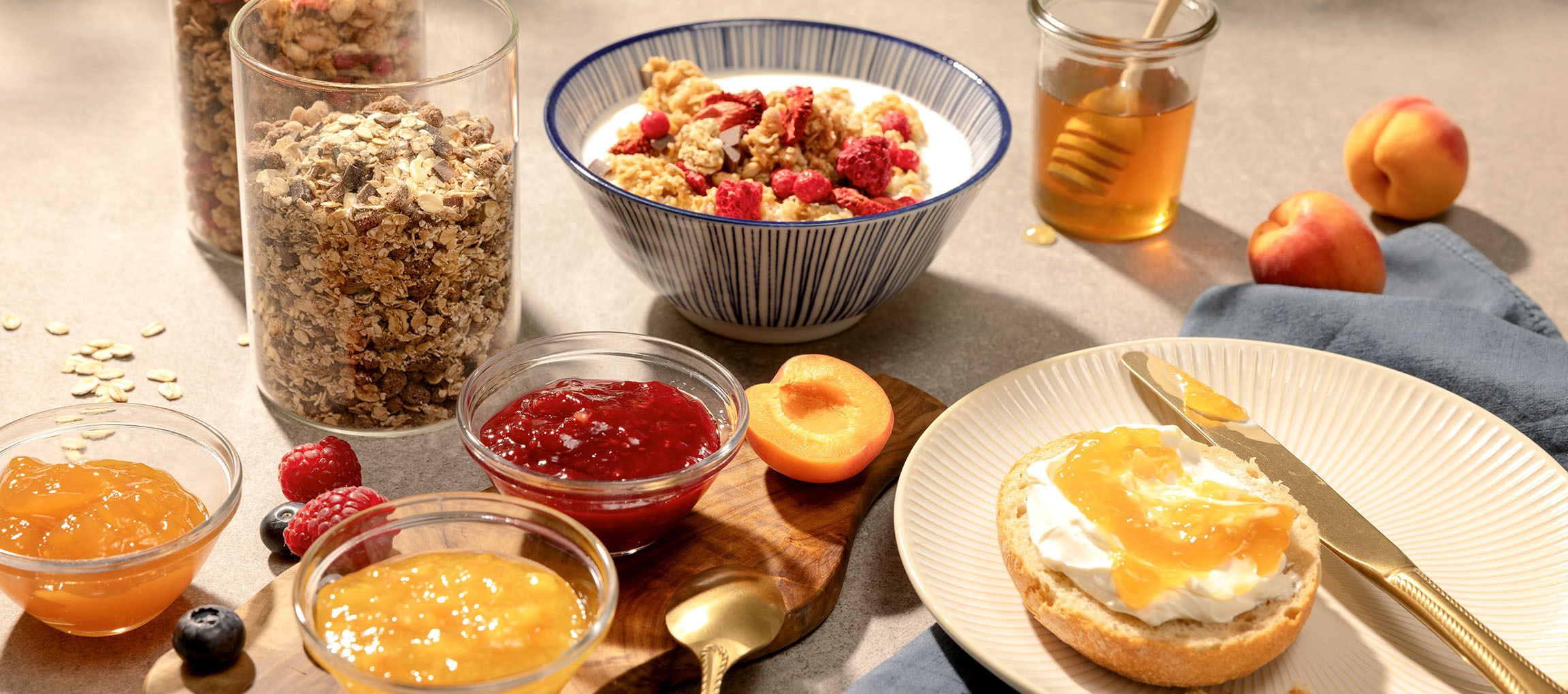 Frukost med müsli, sylt, honung och bröd med färskost och sylt.