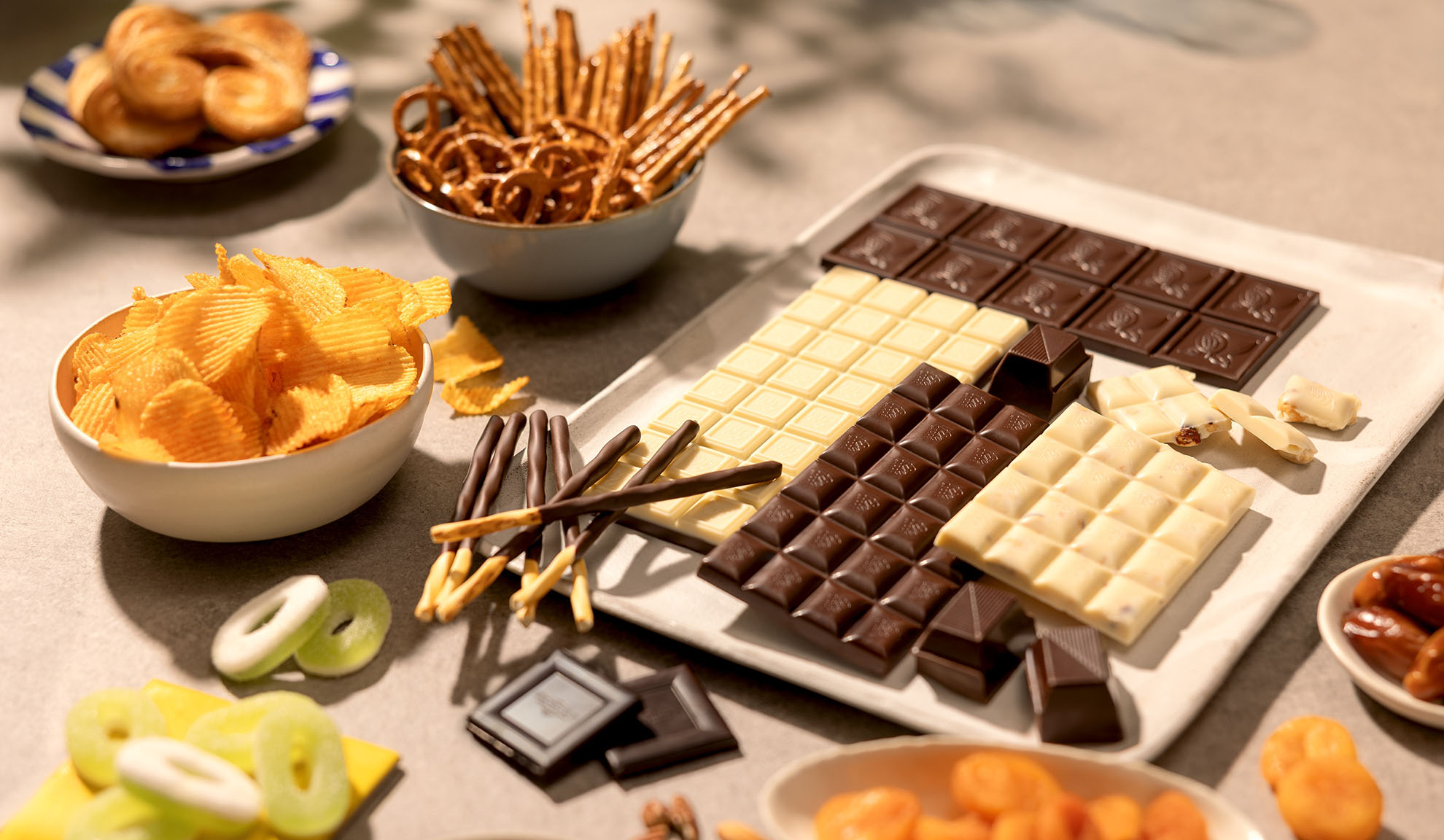 Ett sortiment av snacks inklusive chokladkakor, potatischips, kringlor och godis.