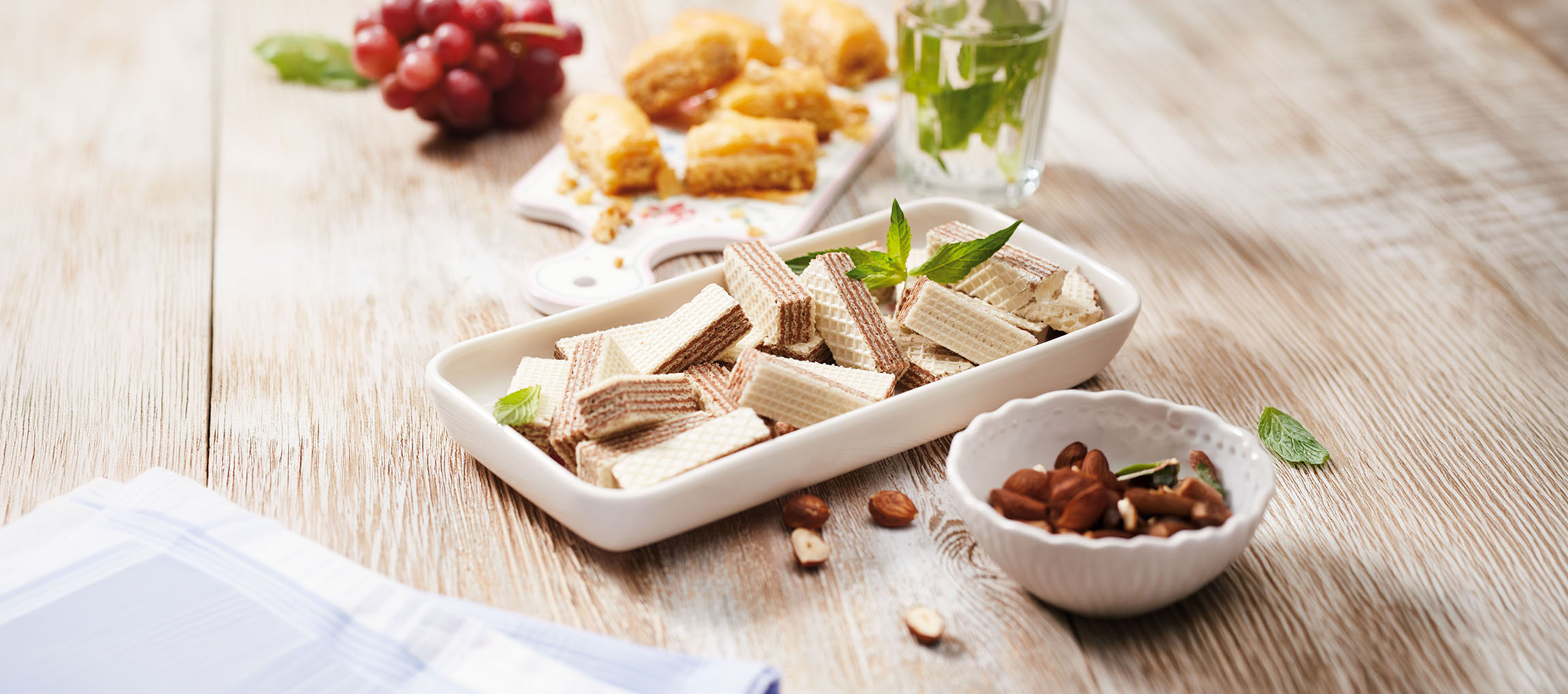 Rånkakor, baklava, vindruvor och myntavatten på ett träbord.