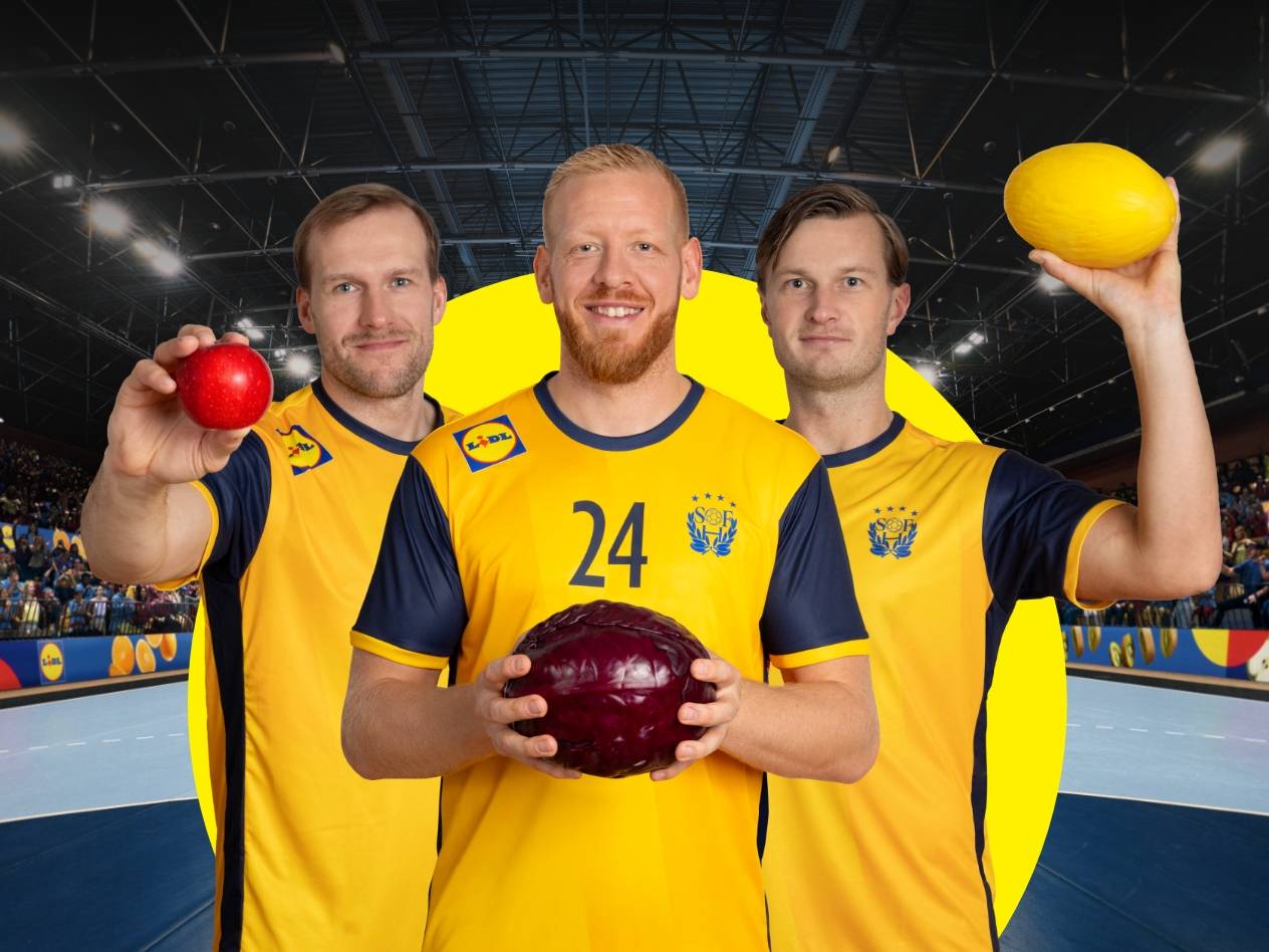 Tre handbollsspelare i gula tröjor håller i en röd frukt, ett rödkålshuvud och en gul melon.