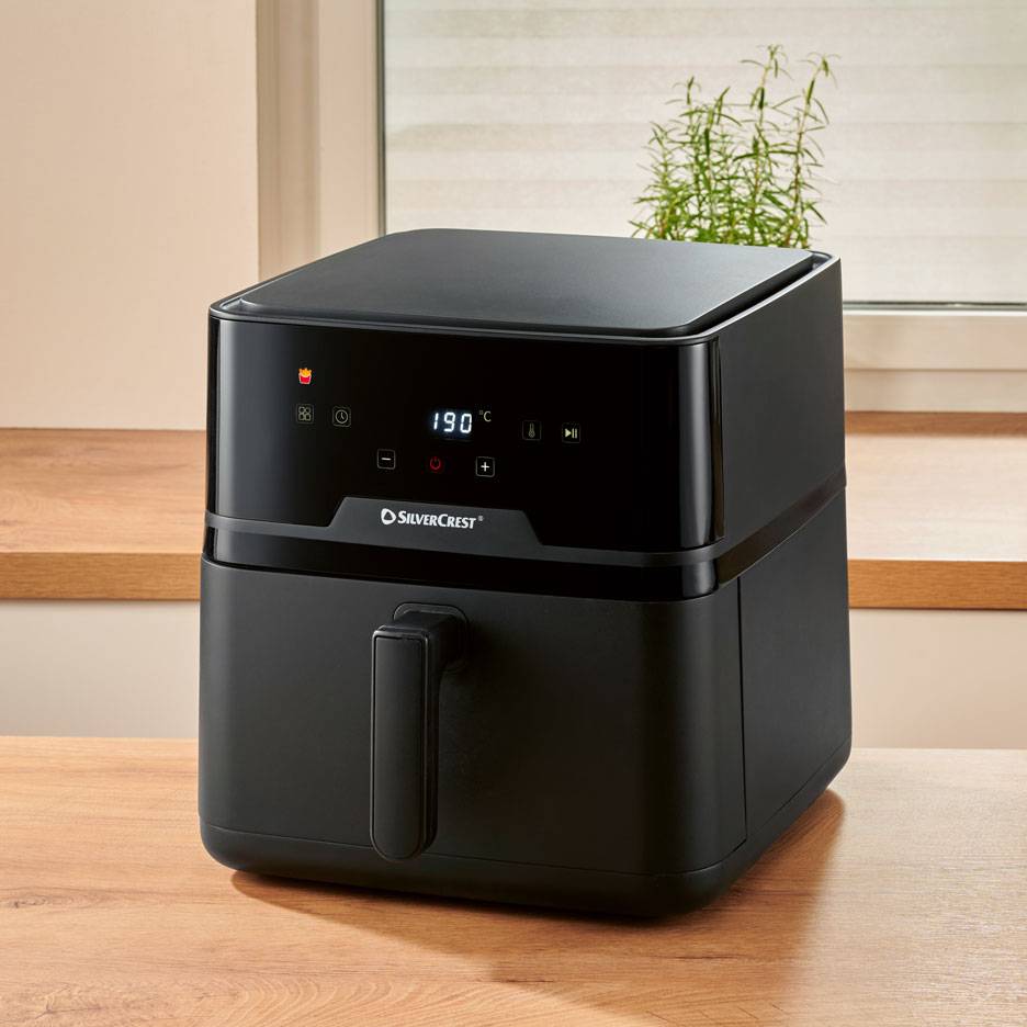 Svart digital airfryer på ett träbord, med 190 °C på displayen.