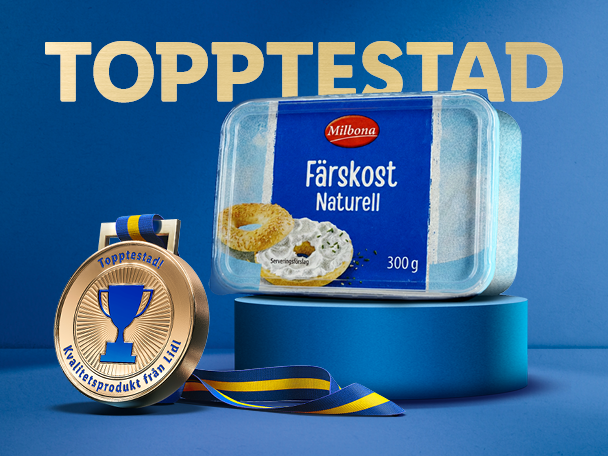 Förpackning med färskost på en blå piedestal bredvid en guldmedalj med texten 'Topptestad'.