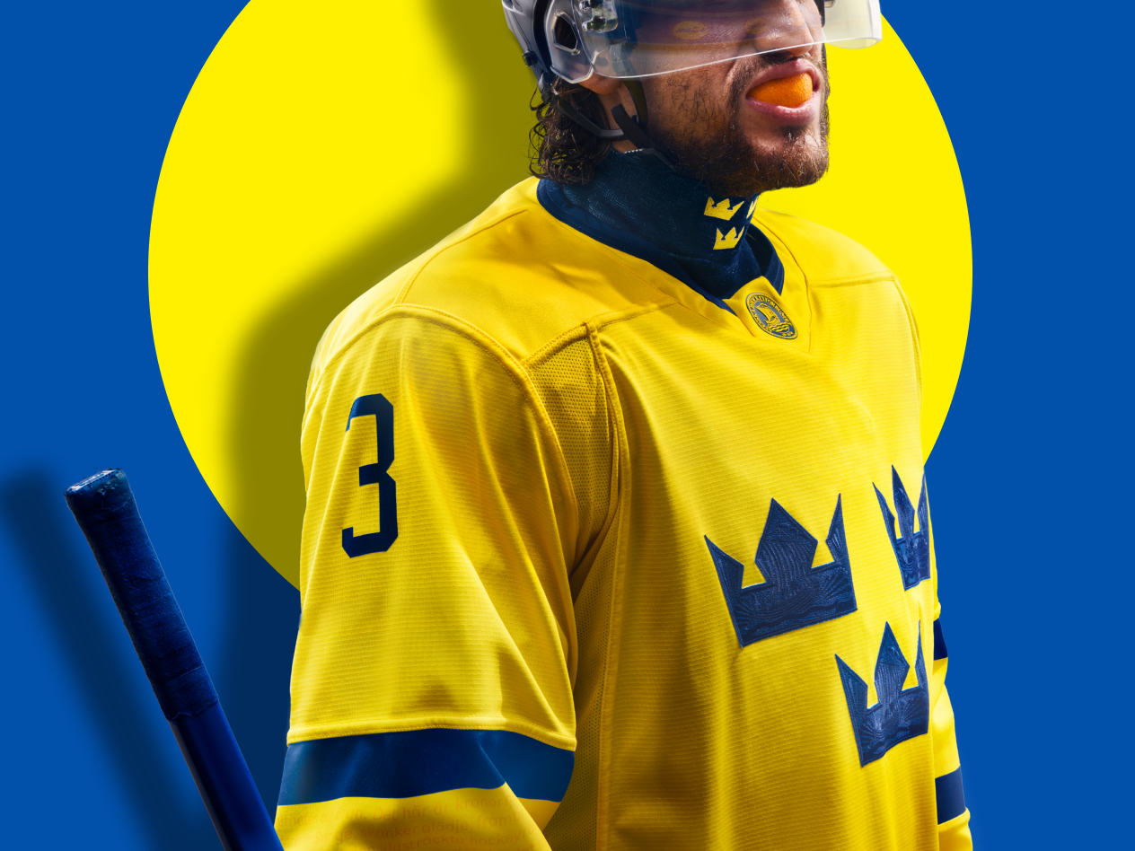 Ishockeyspelare i gul tröja med nummer 3 och tre kronor, med en blå bakgrund.