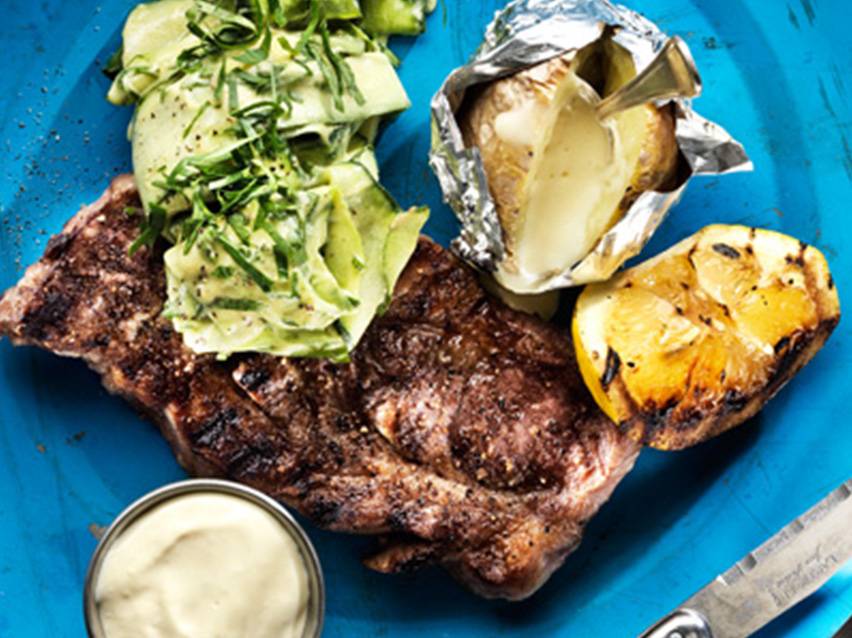 Grillade kotletter, bakpotatis, citron och zucchini-sallad.