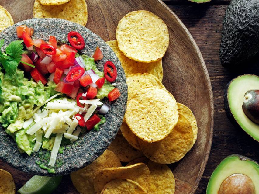 Guacamole, nachochips och avokado.