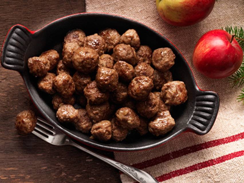 Stekta köttbullar i en gjutjärnspanna.