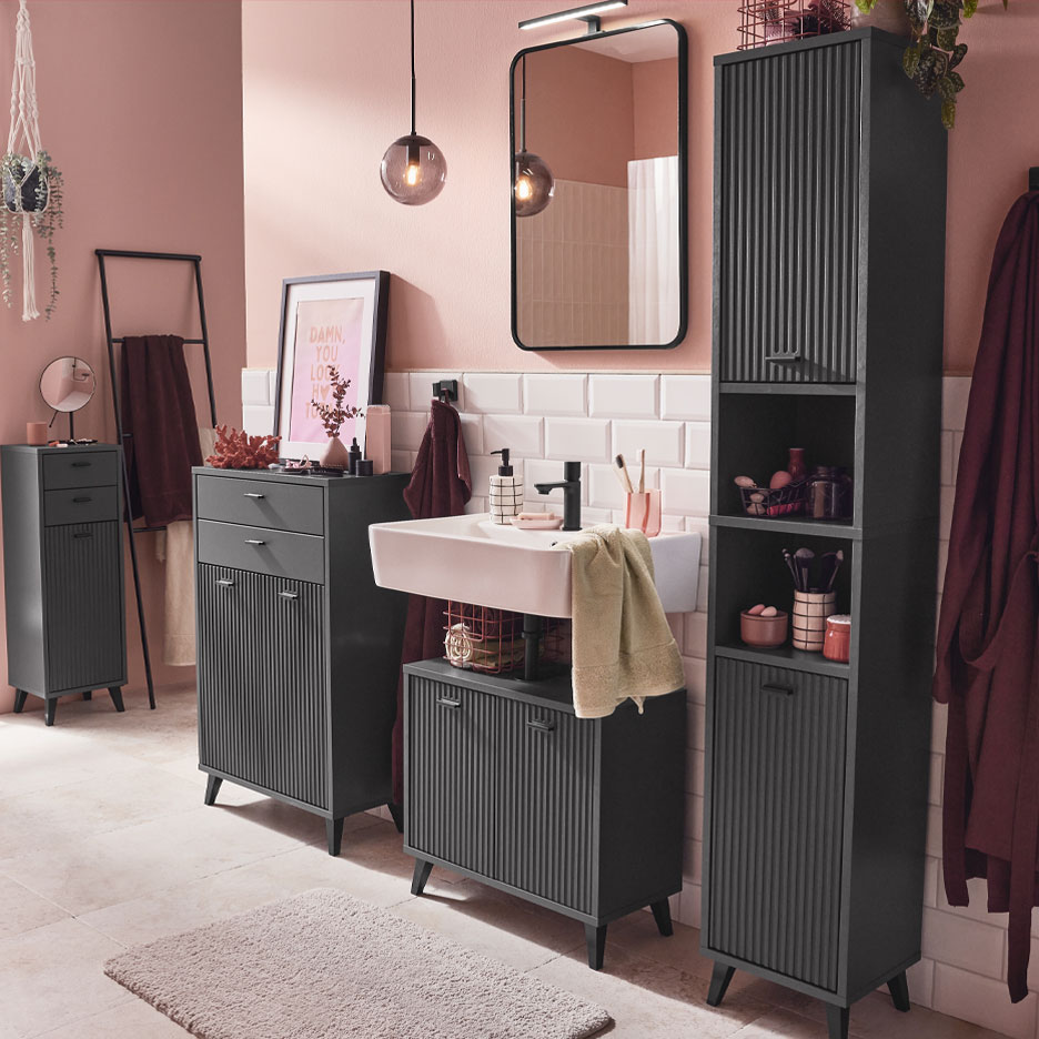 Modernt badrum med mörkgrå möbler och rosa accenter.