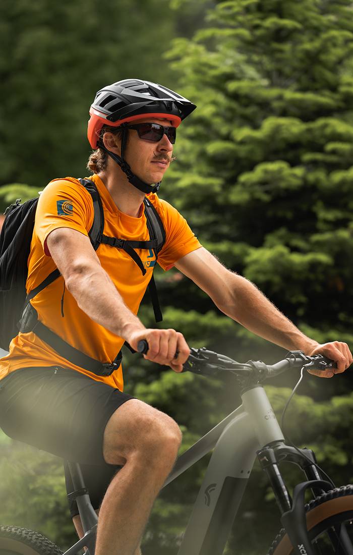 Man cyklar på mountainbike med hjälm och sportkläder.