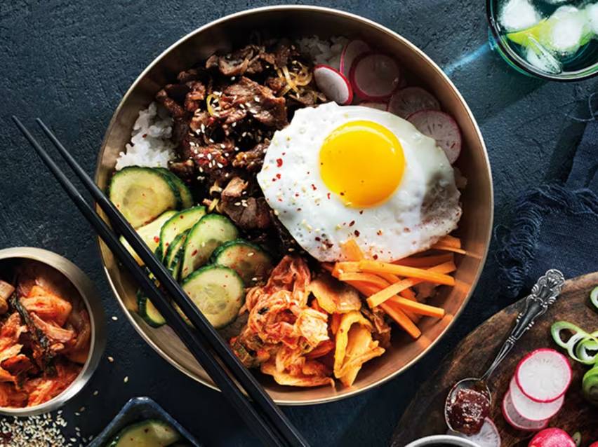 Bibimbap med stekt ägg, nötkött, gurka, kimchi och inlagd rättika.