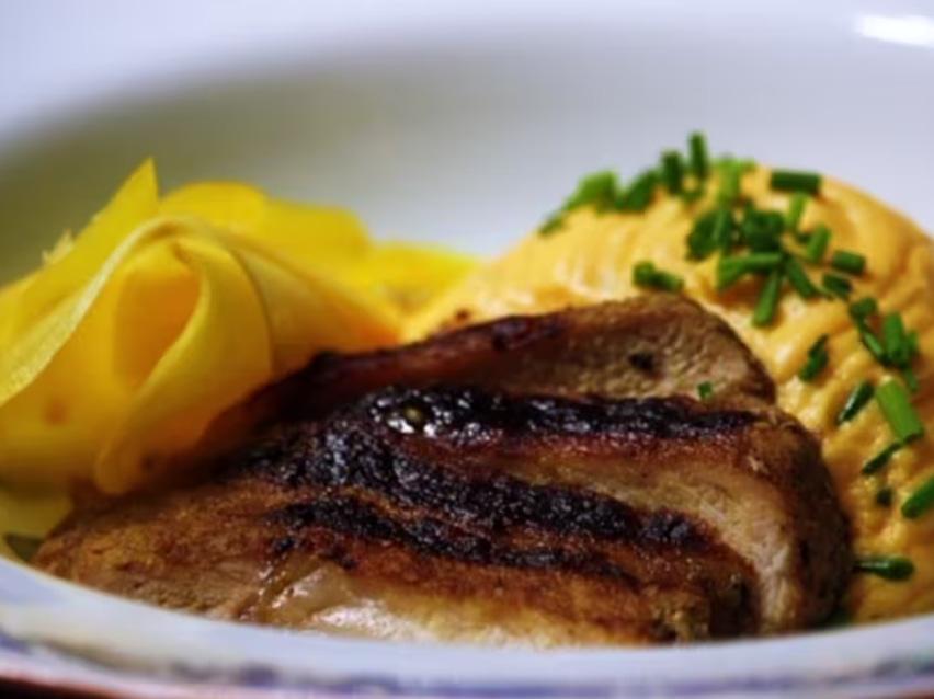 Stekt kött serverat med krämigt mos och hyvlad gulbeta.