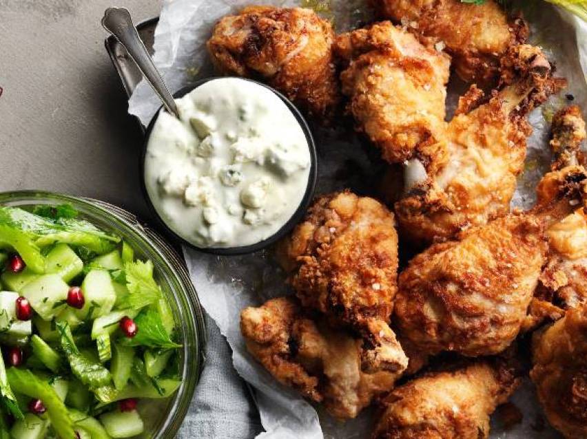 Friterad kyckling med gräddfilssås och en sallad med gurka och granatäpple.