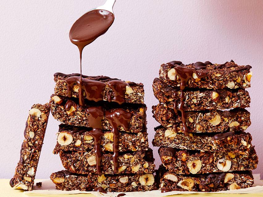 Choklad- och hasselnötsbars staplade på varandra med chokladsås som rinner över.