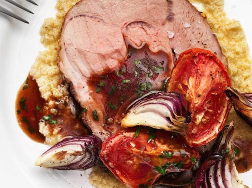 Skivad lammstek med rödvinssås, polenta, ugnsrostade tomater och rödlök.