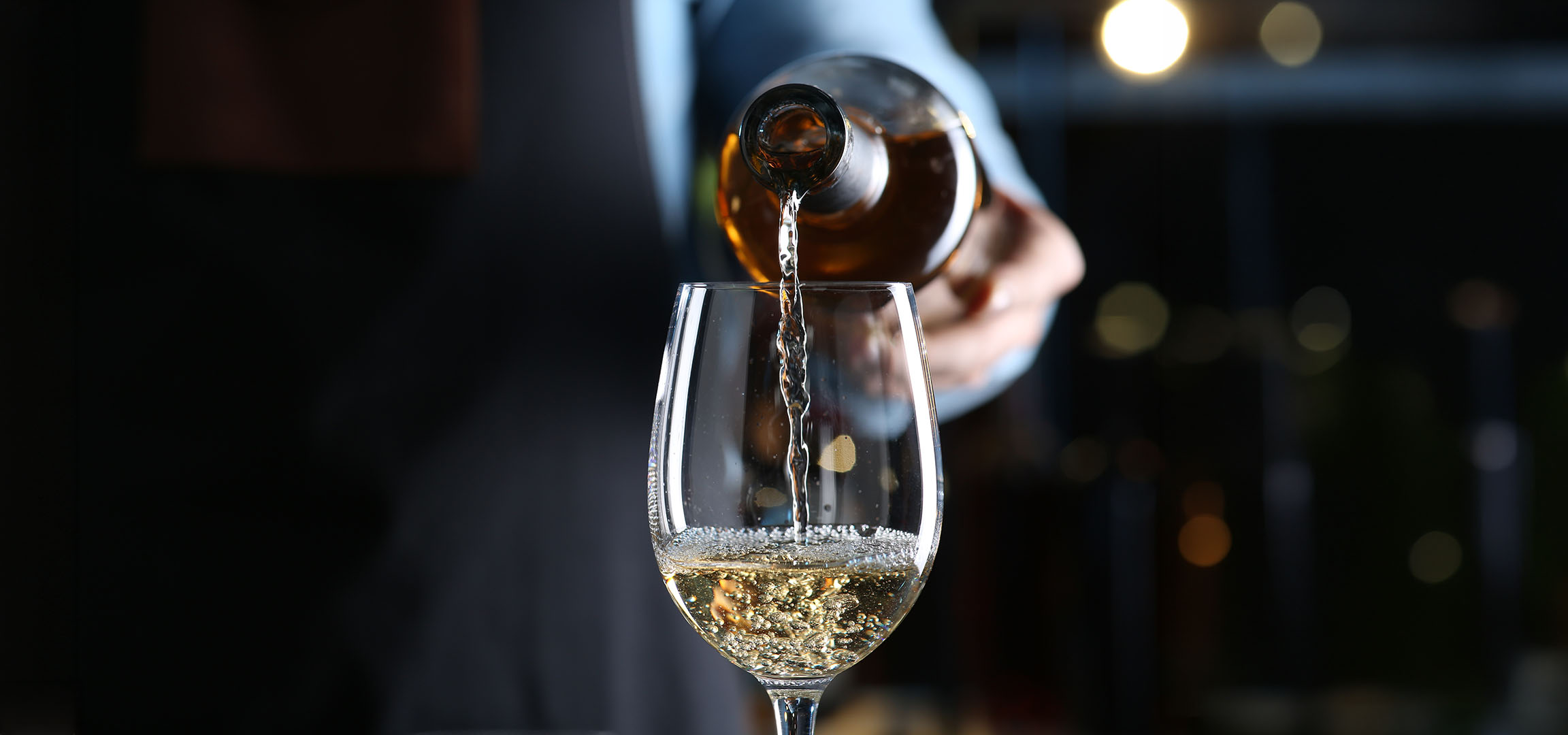 Vitt vin hälls upp i ett glas.