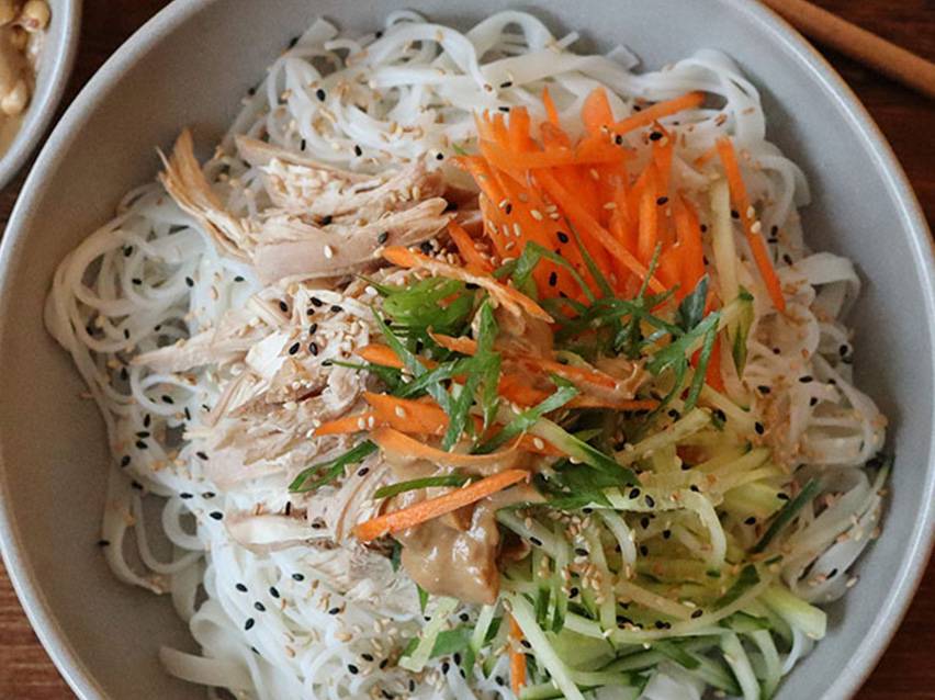 Kycklingnudlar med morötter, gurka och tahinisås.