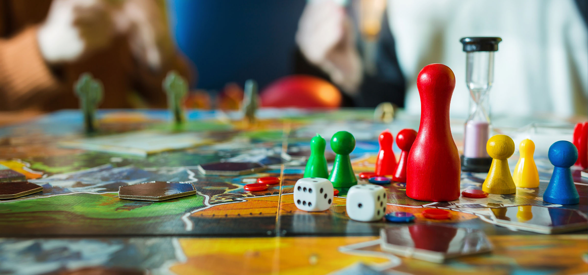 Färgglada brädspelsbitar, inklusive röda, gröna, gula och blå pjäser, med tärningar.