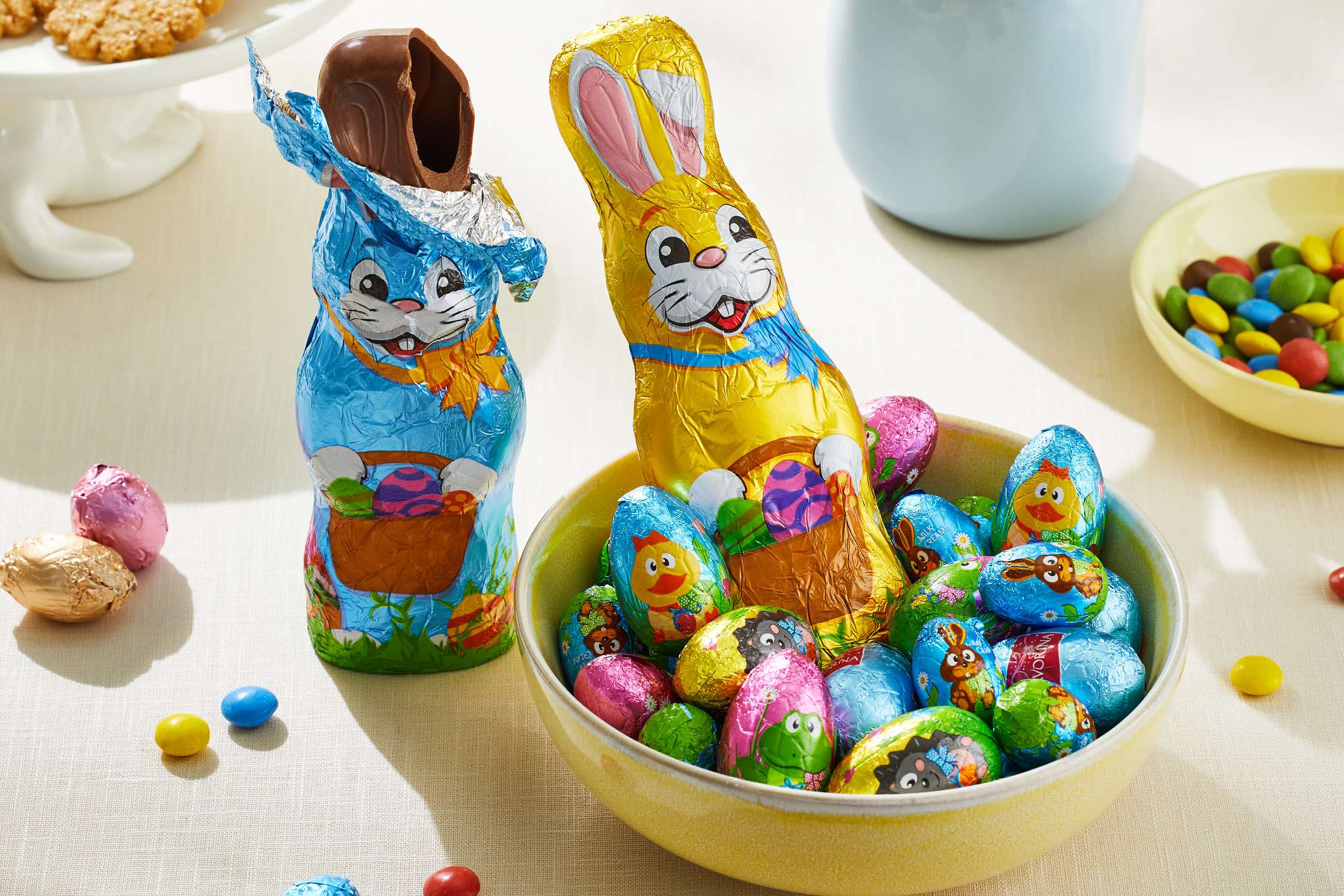 Chokladkaniner och chokladägg i folieinpackning, tillsammans med godis och kakor.