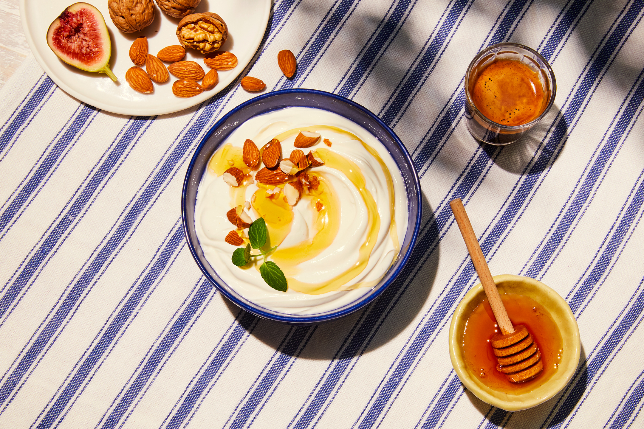 Yoghurt med honung, mandel och mynta, tillsammans med fikon, valnötter och kaffe.