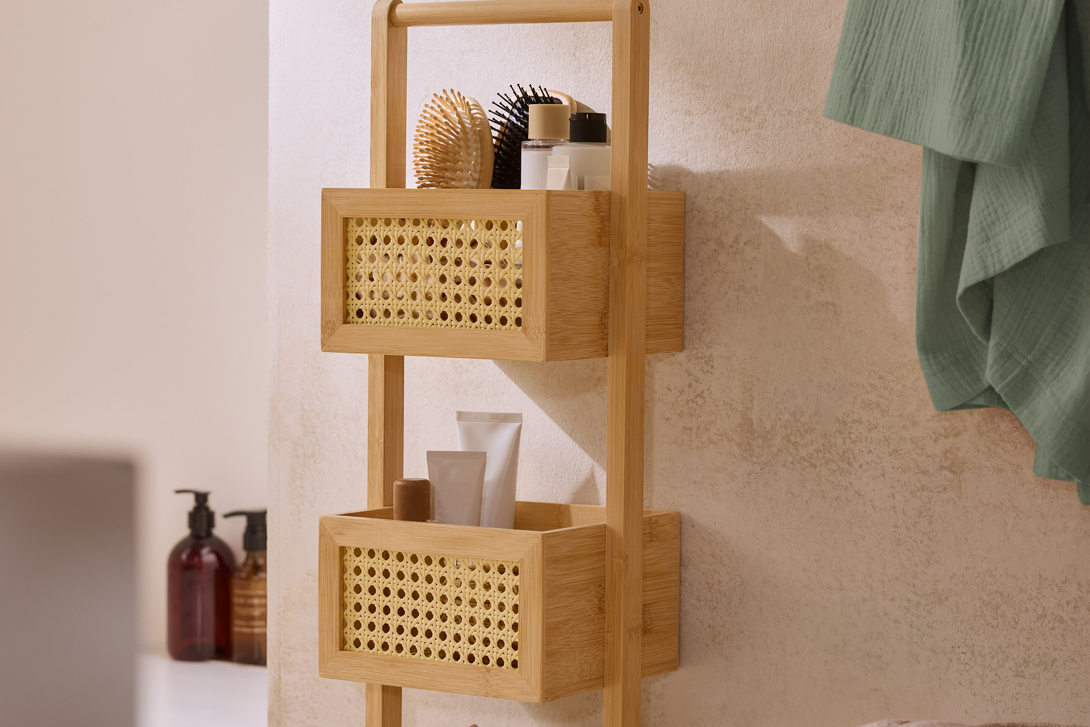 Bambu badrumshylla med rottingdetaljer, fylld med borstar och krämer.