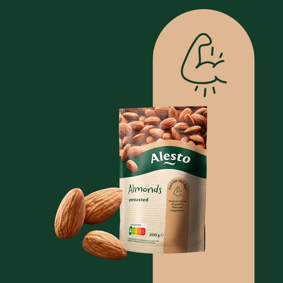 En påse orostade mandlar med tre lösa mandlar bredvid, mot en grön och beige bakgrund.