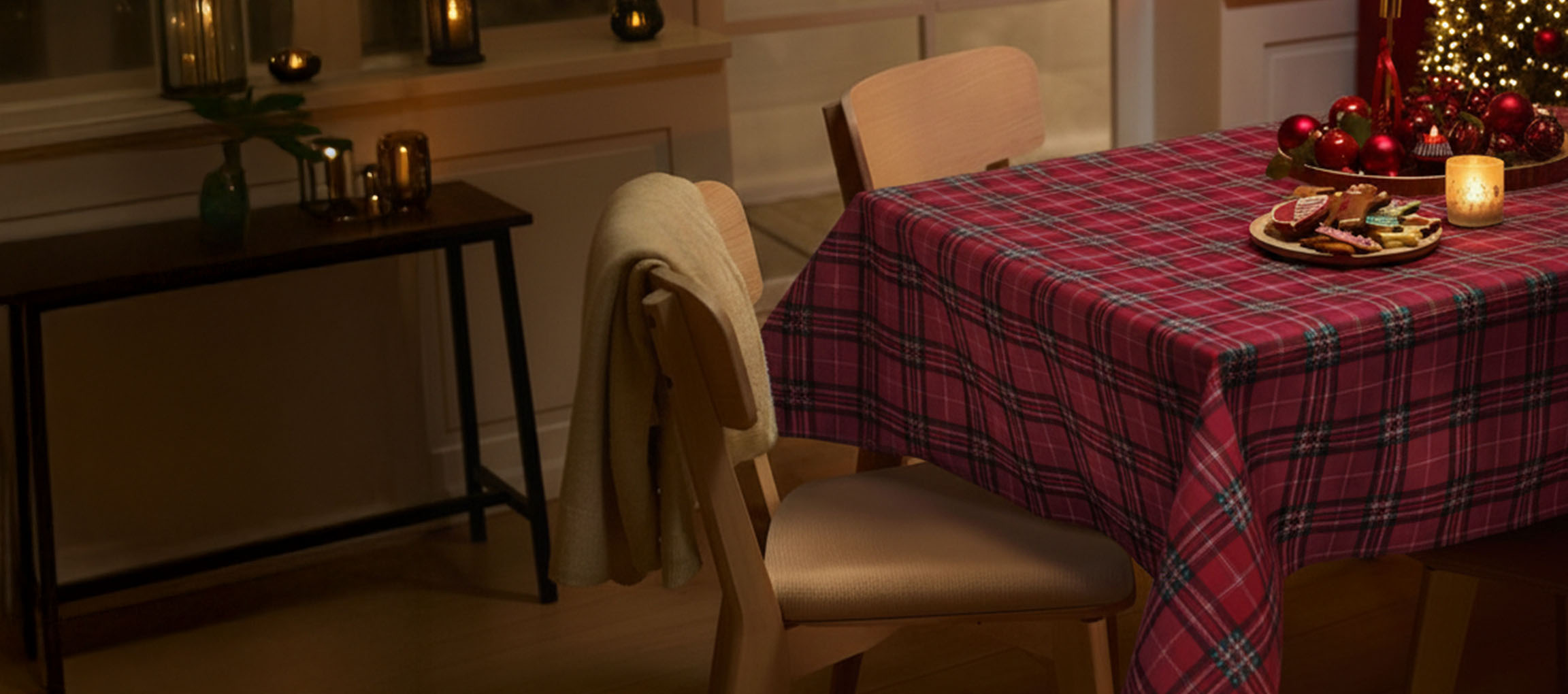 Juldukning med rödplädad duk, stolar och julkakor.