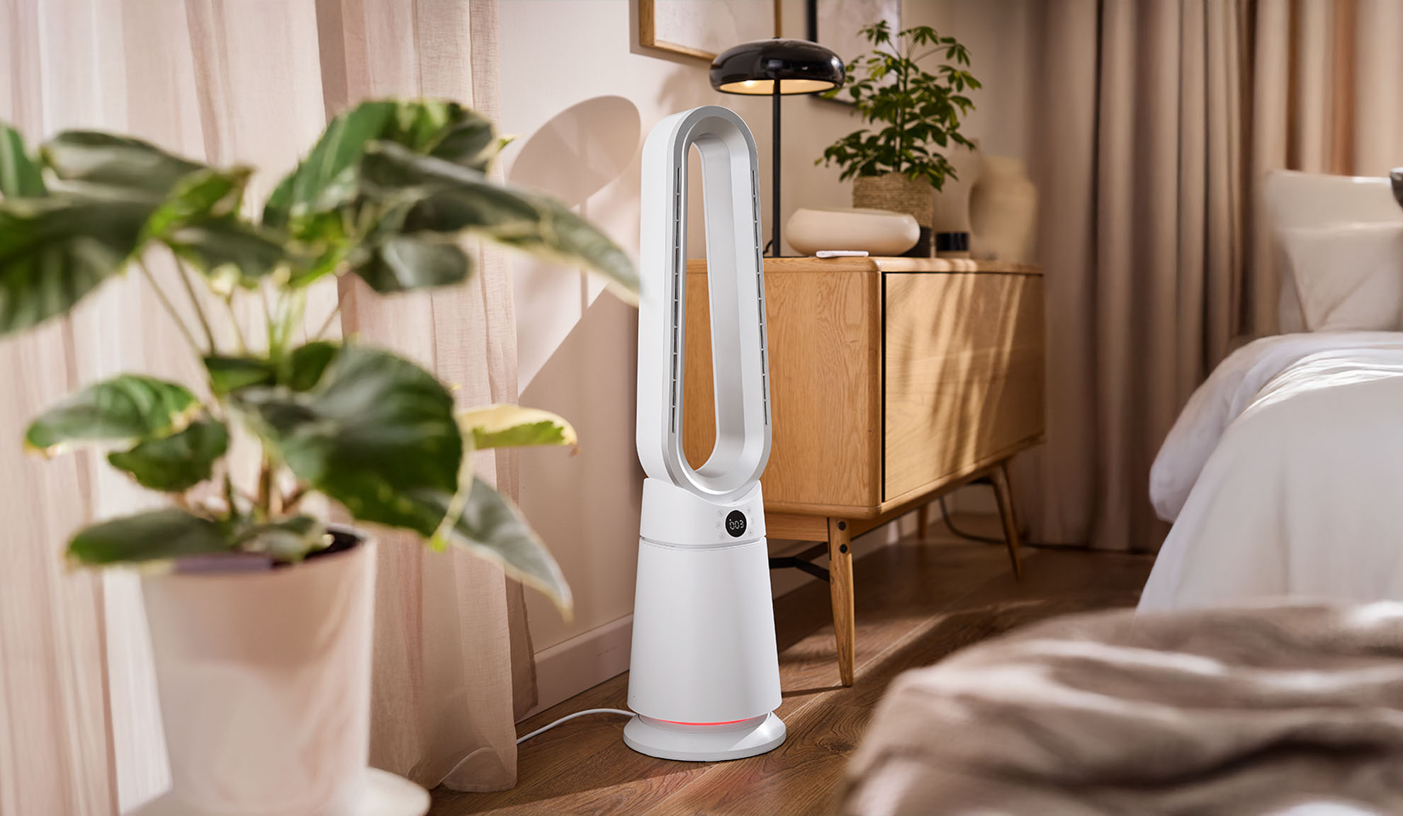 Vit tornfläkt i ett modernt sovrum med växter och trämöbler.