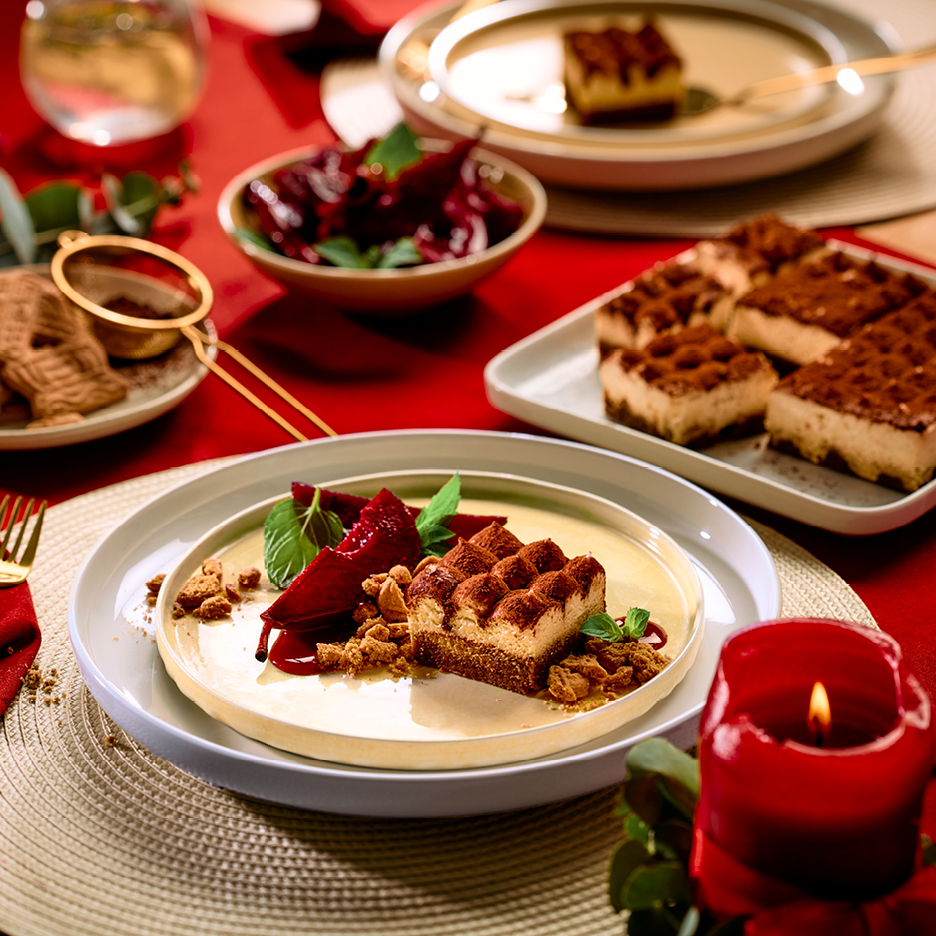 Juligt dukat bord med tiramisu, pepparkakor och rödbetor.
