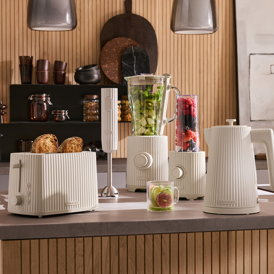 Kök med beige brödrost, vattenkokare, stavmixer och blenders med frukt.