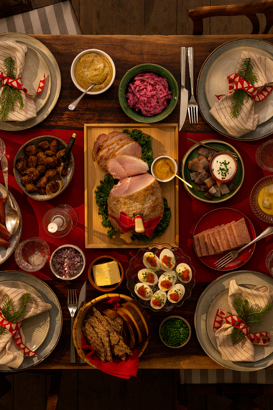 Julbord med skinka, prinskorv, lax, sill, potatis och andra traditionella rätter.