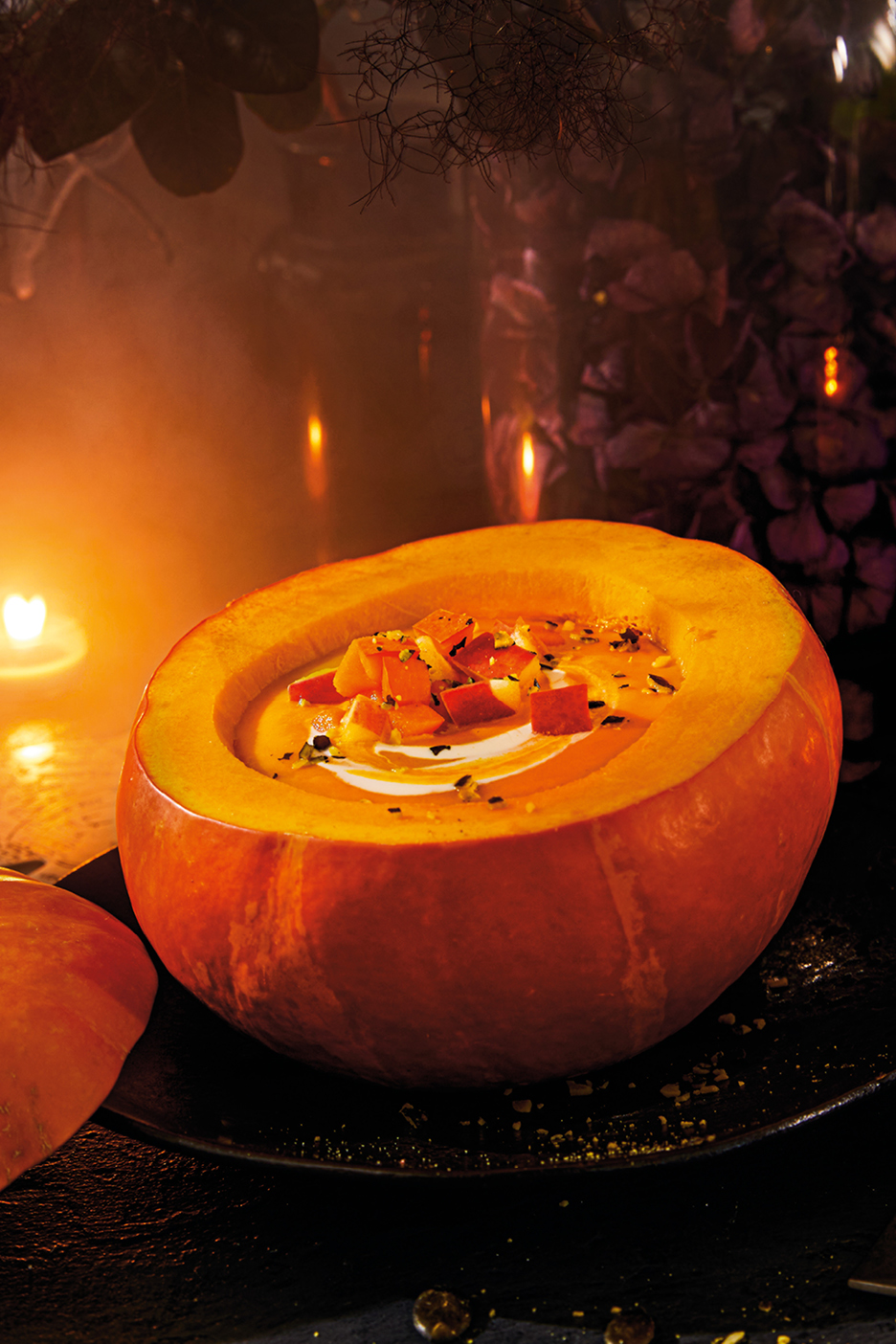 Pumpasoppa serverad i en urgröpt pumpa, med tärnade grönsaker och grädde, i en mysig höstmiljö.