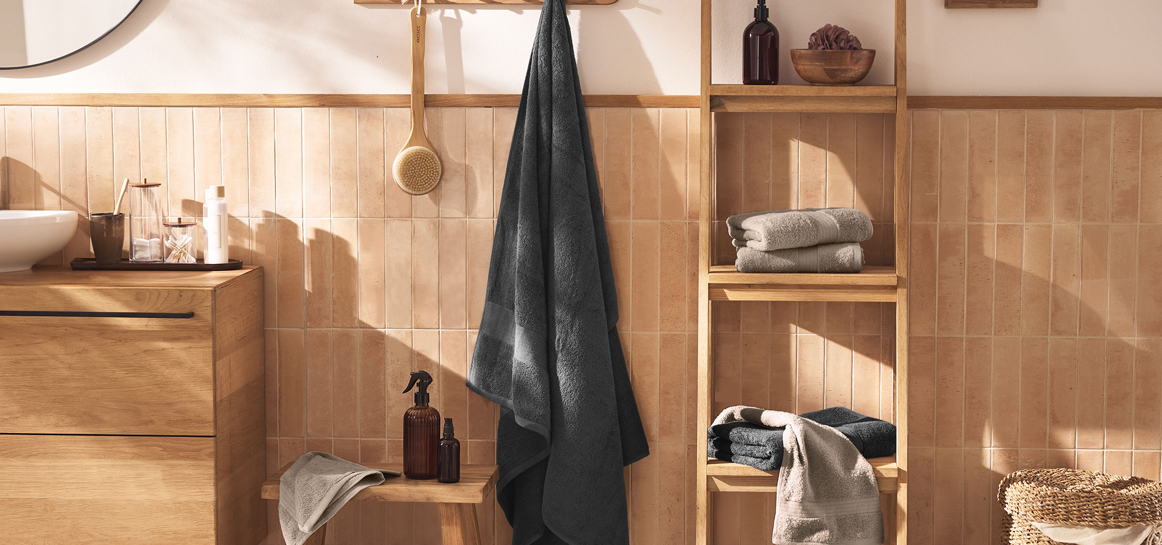 aiLabeling.aiLabelForImageAltText: Modernt badrum med handfat, träskåp, handdukar och tillbehör.