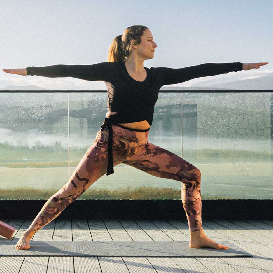 Kvinna i leggings och yogatopp på en terrass