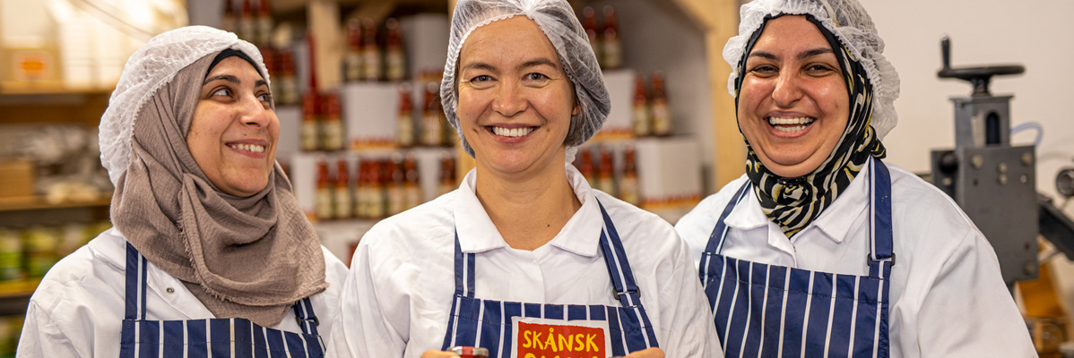 Leende anställda som gör Skånsk såser.