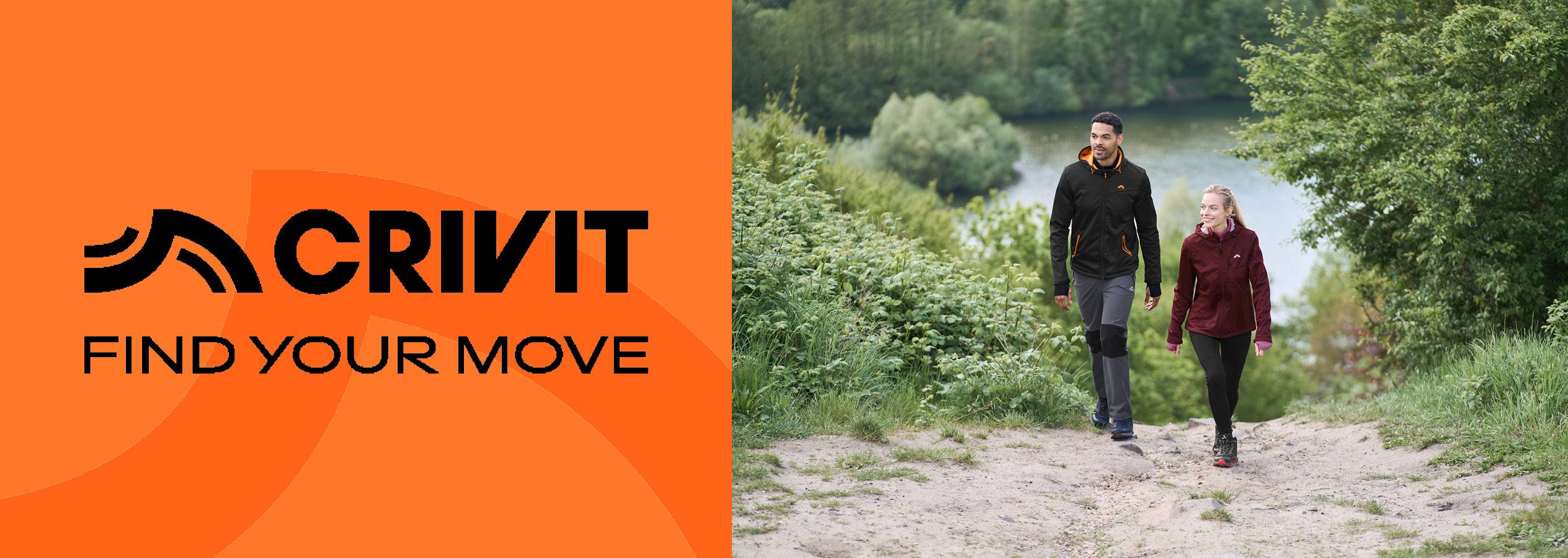 Två personer i sportkläder vandrar på en stig vid en sjö, med Crivit-logotypen.