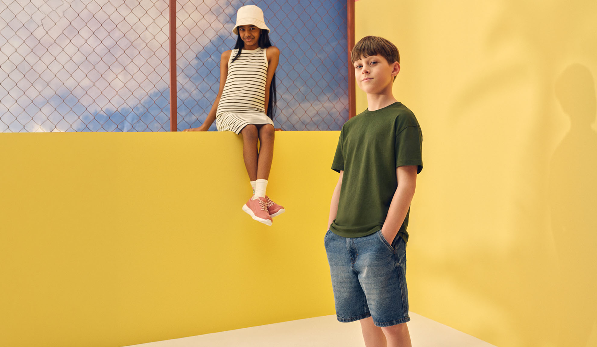 Flicka i randig klänning och pojke i t-shirt och jeansshorts.