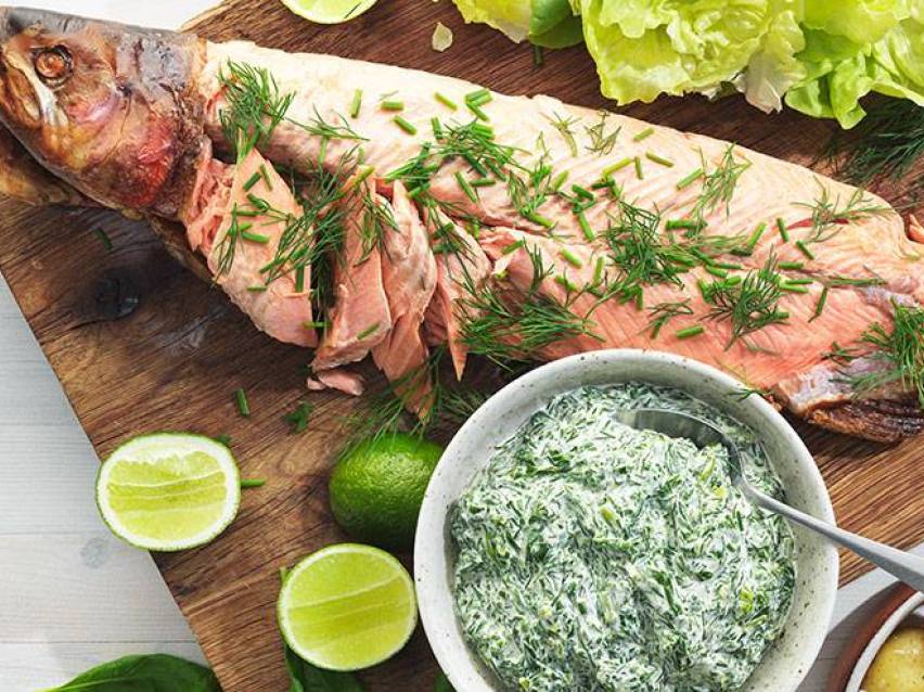 Rökt lax serveras med en krämig spenatsås och lime.