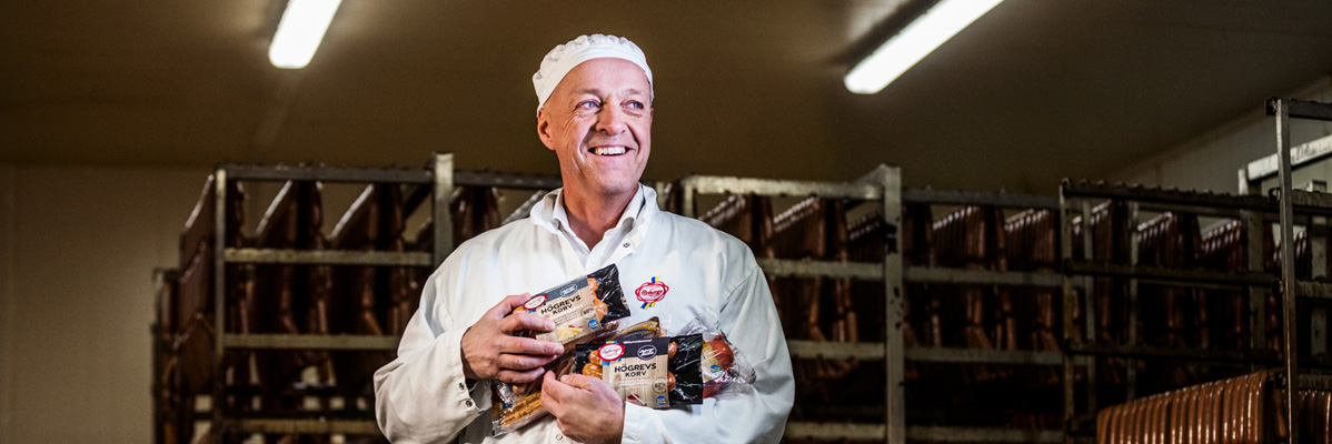 Man håller i Höggrevs korv i en charkuteri.