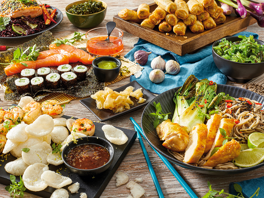 En spännande spridning av asiatisk mat, inklusive sushi, vårrullar och nudlar.
