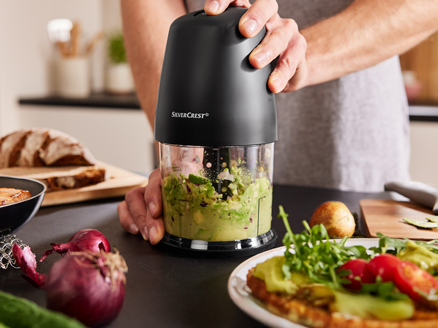 En person använder en SilverCrest matberedare för att göra guacamole.