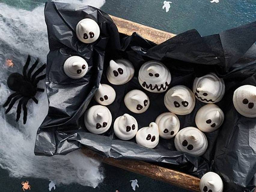 Spökliknande maränger i en låda med spindelnät och en spindel, för Halloween.
