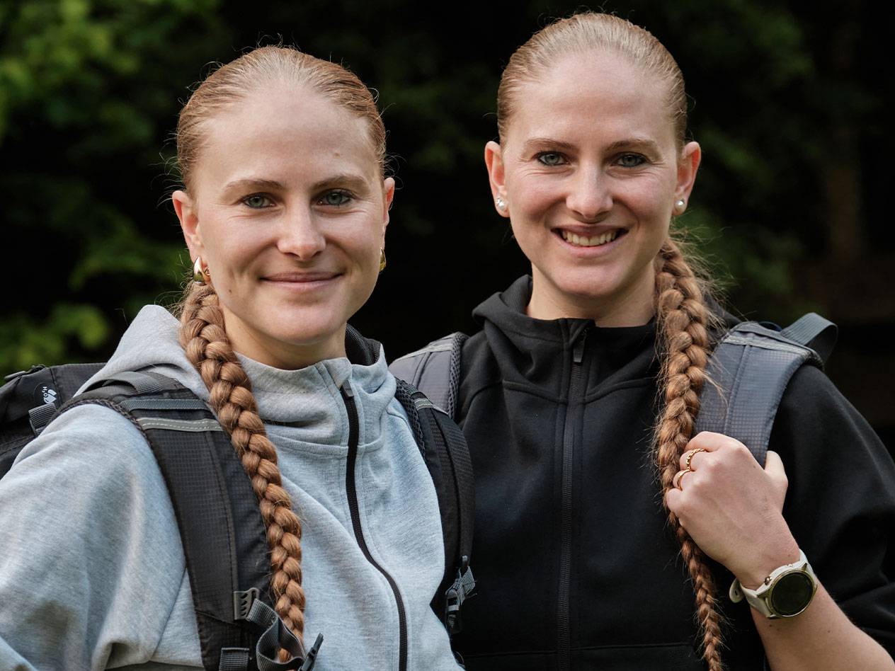 Två kvinnor med ryggsäckar står tillsammans.