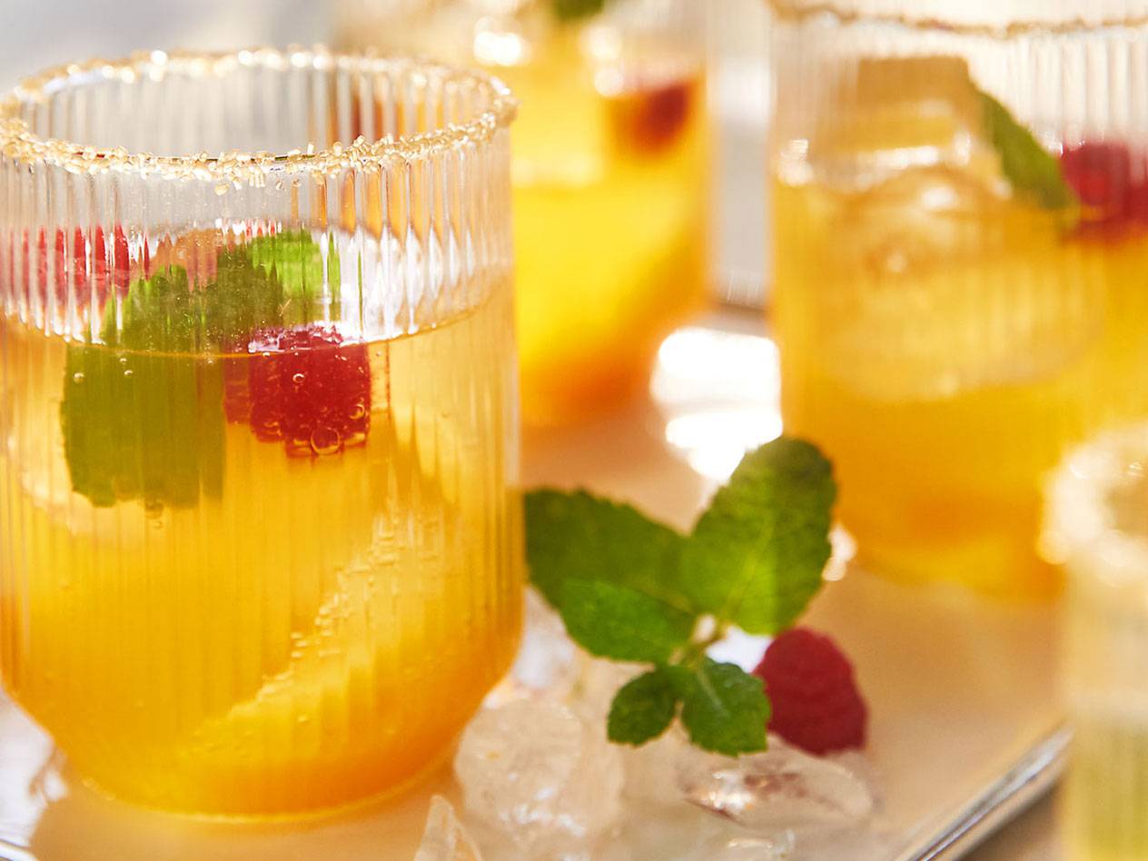 Uppfriskande gula drinkar med hallon, mynta och sockerkanter på glasen.